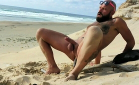 Tattooed guy drills his ass and jerks his cock on the beach